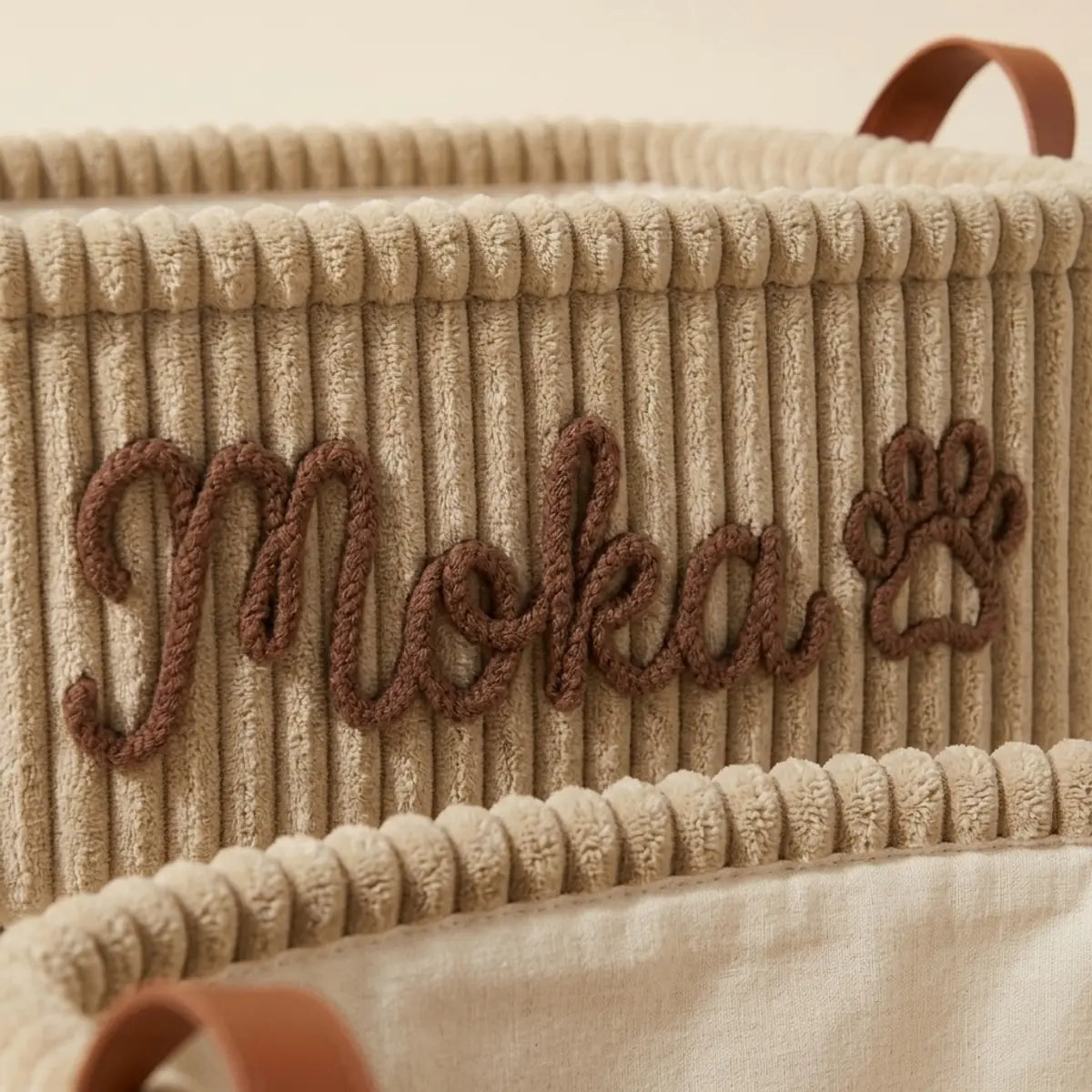 Gros plan sur la broderie en relief du prénom sur le velours côtelé