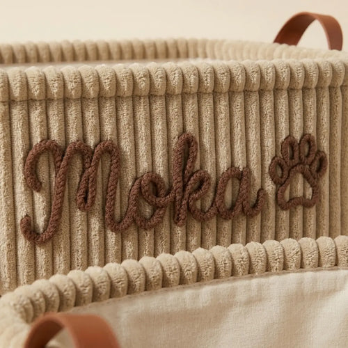 Gros plan sur la broderie en relief du prénom sur le velours côtelé
